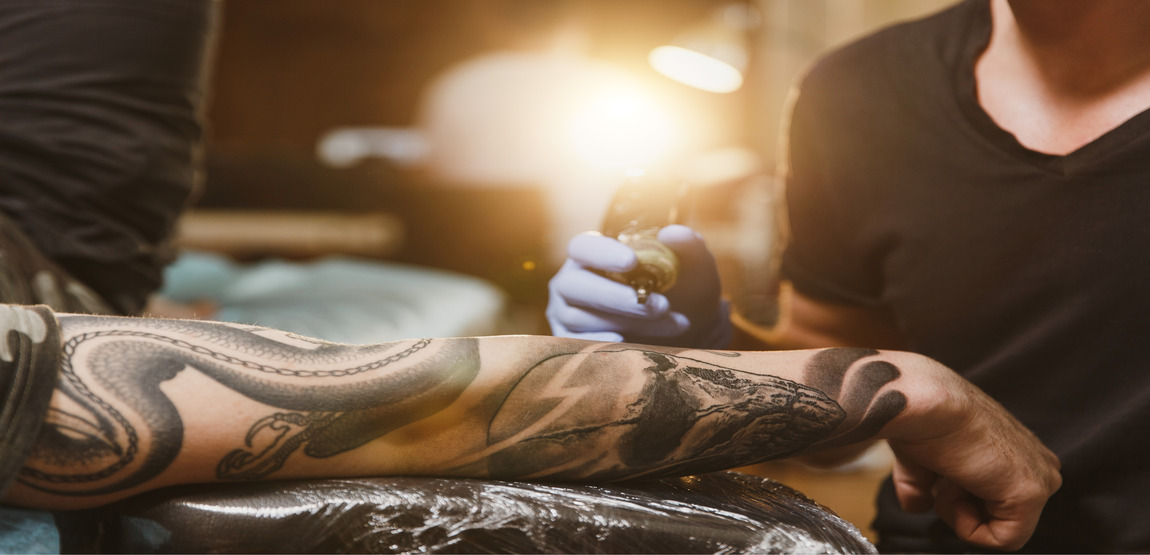 Tattoo artist tattooing client