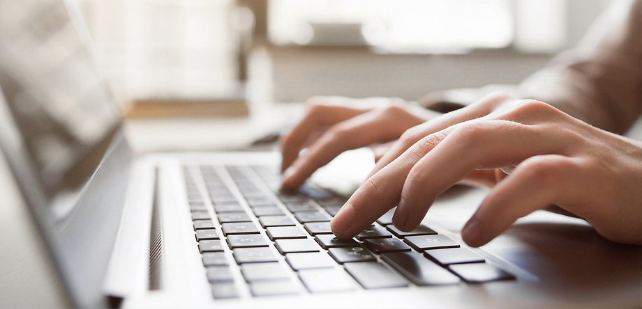 Hands typing on laptop